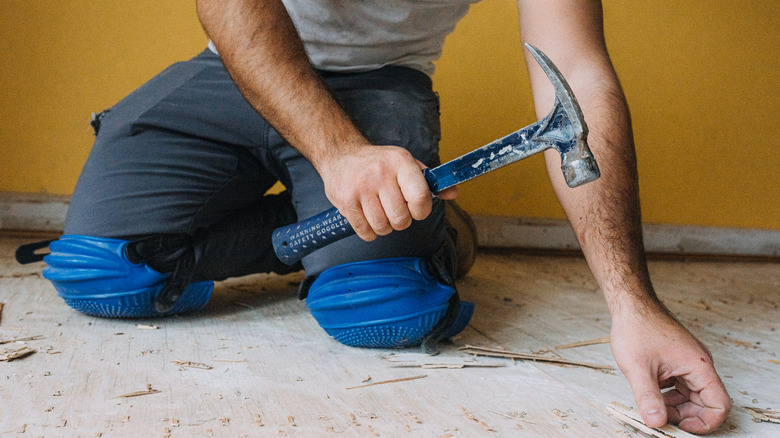 Person using a metal hammer on the floor