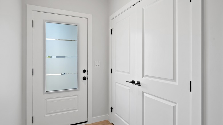 White door with a frosted glass window and a black handle.