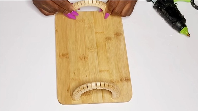 Hands place a handle on a DIY wooden tray.