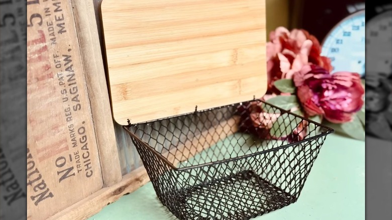 A black wire basket with a wooden DIY lid.
