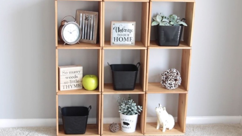 A set of 9 storage cubes stand side-by-side in columns of three with various decor items in each.