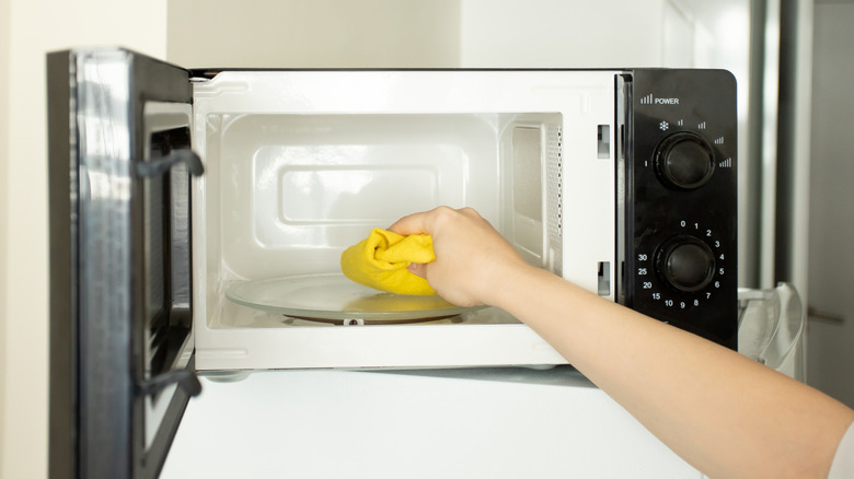 Woman cleaning a microwave