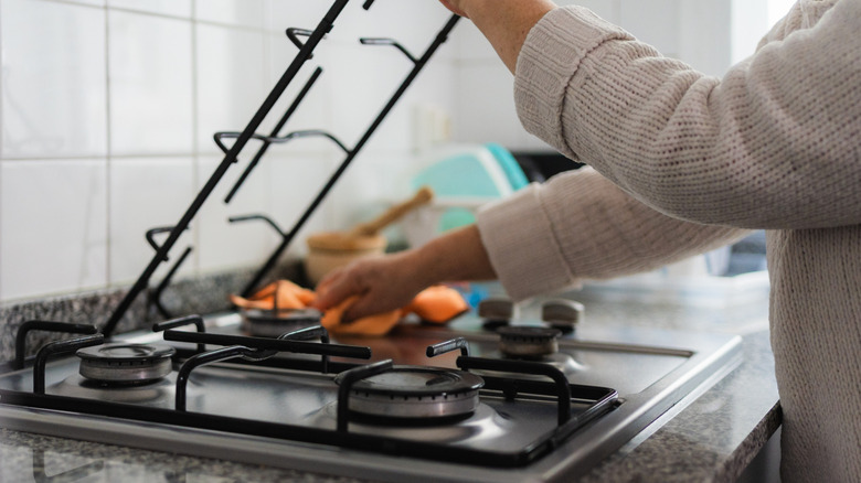 Women cleaning a gas stovetop