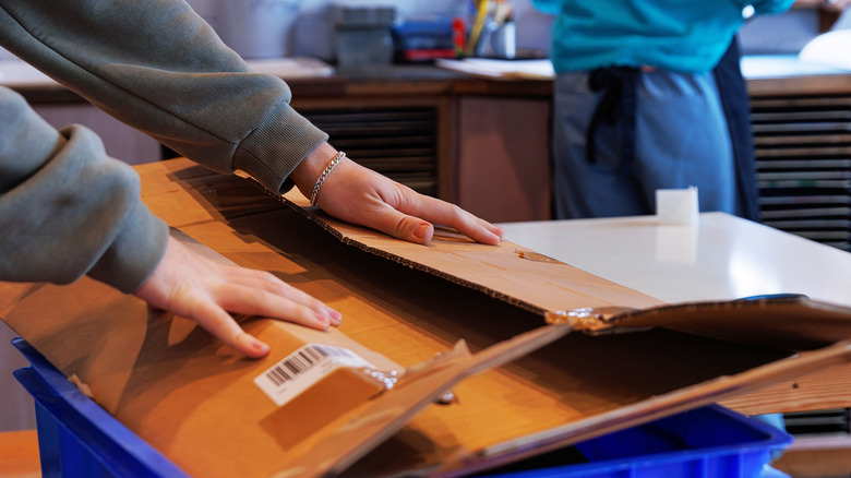Person breaking down cardboard boxes