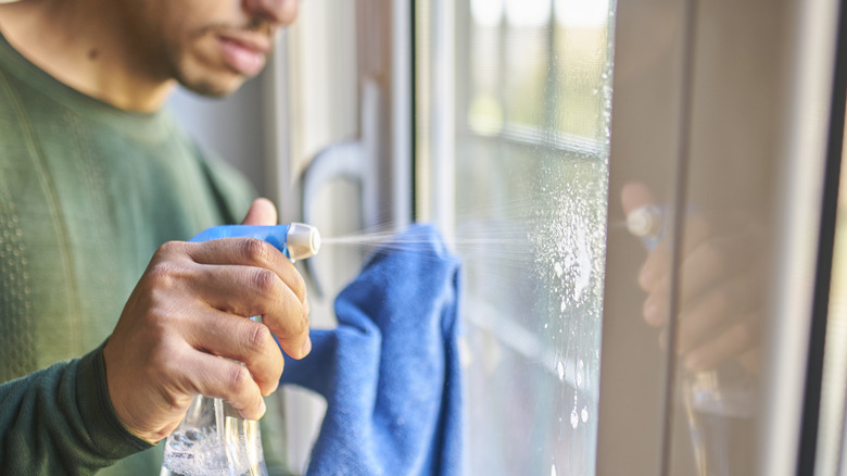 Man cleaning a door window