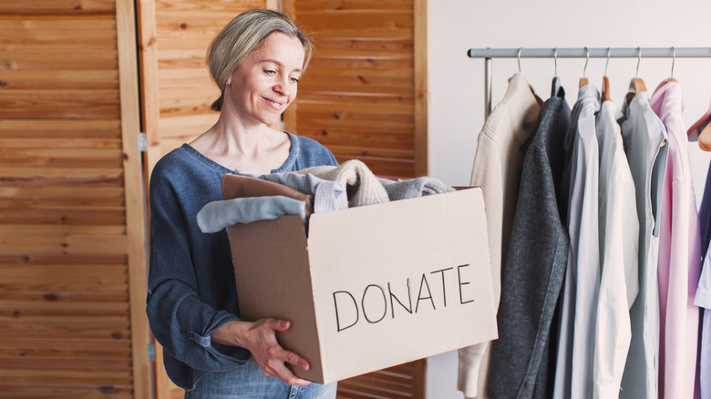 A person holding a box of clothes to donate