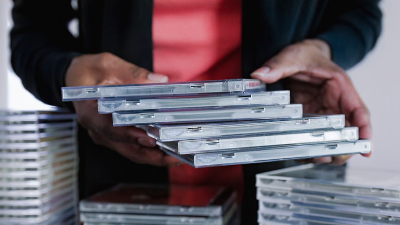 A person holding CD cases