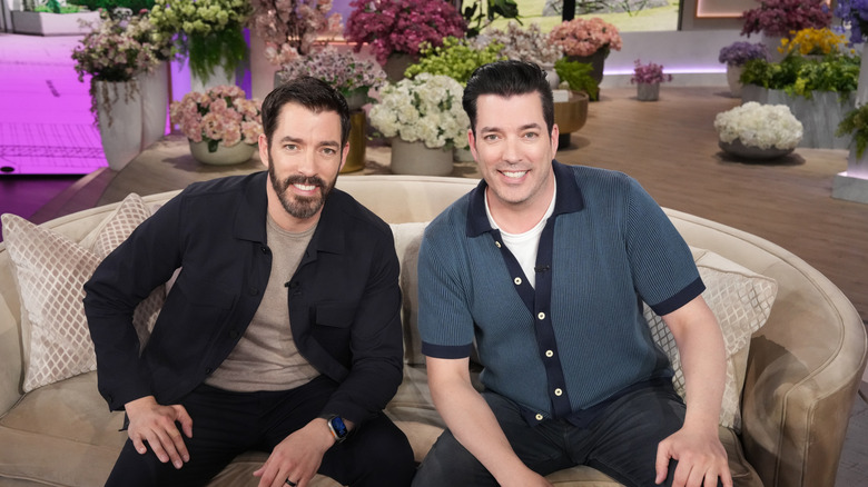 the property brothers sit on a couch for a tv interview