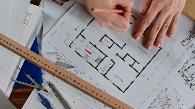 Person's hands drawing out a floor plan for a home remodel.