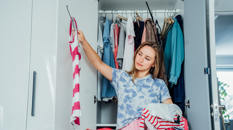 Woman deciding what clothes to keep
