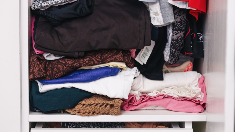 Disorganized shelf of blankets and linens