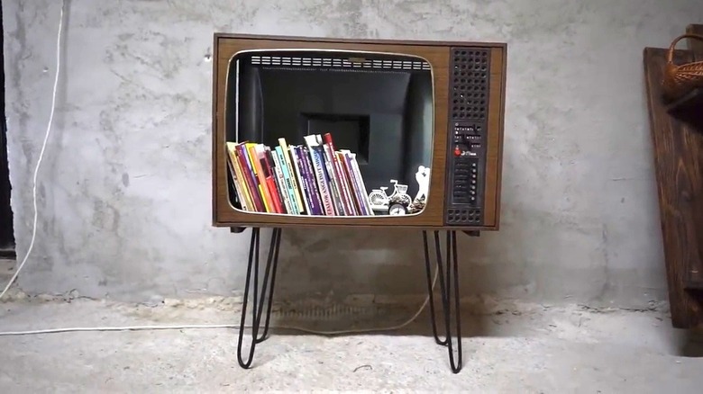 Small vintage TV sits on hairpin legs and functions as a bookshelf