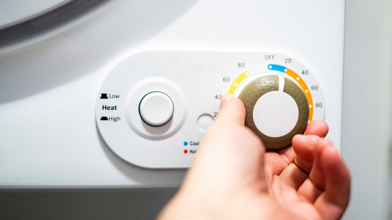 Hand turning the dryer time knob