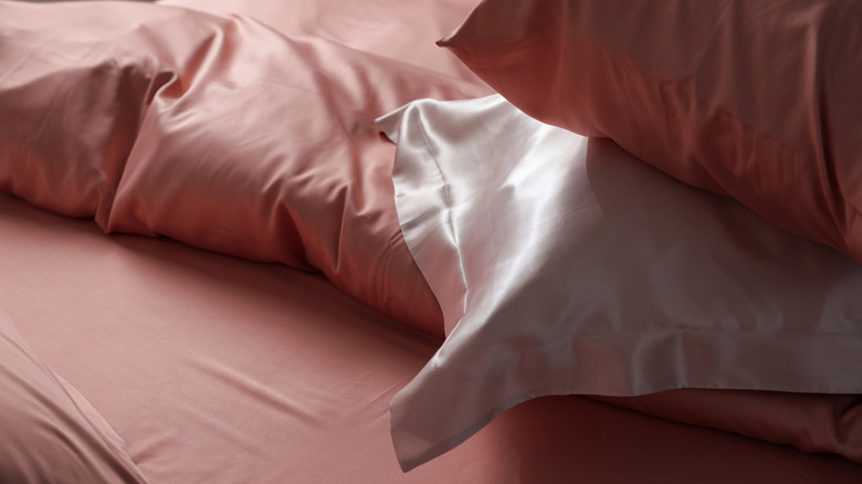 Bed with pink and white satin bedding