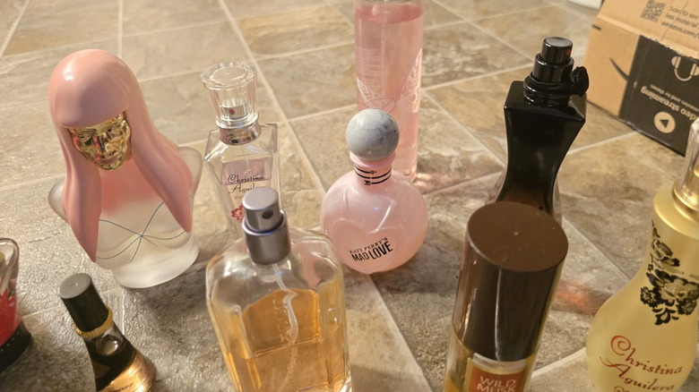 Pre-owned women's perfume bottles on tile floor