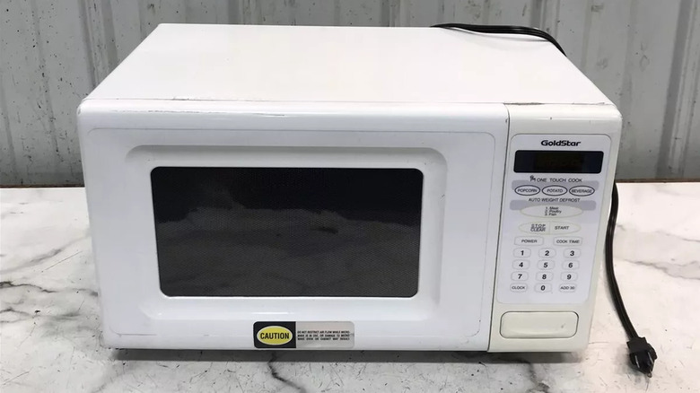 White GoldStar microwave oven on scratched stone tabletop