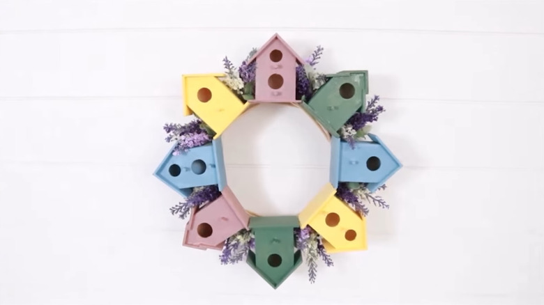 Wreath made of bird houses and fake flowers