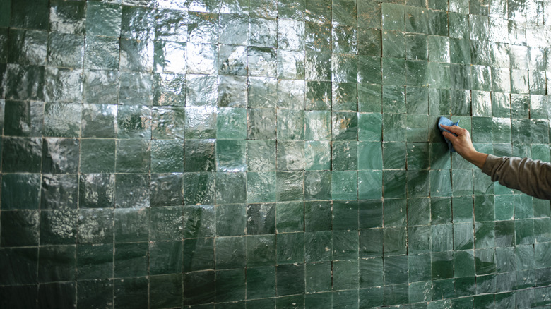 A hand laying zellige tiles