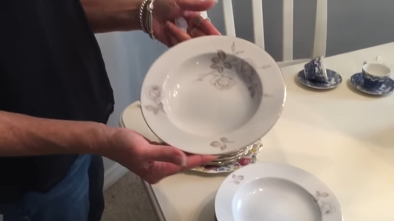 Woman's hand holding a piece of bone china at a table
