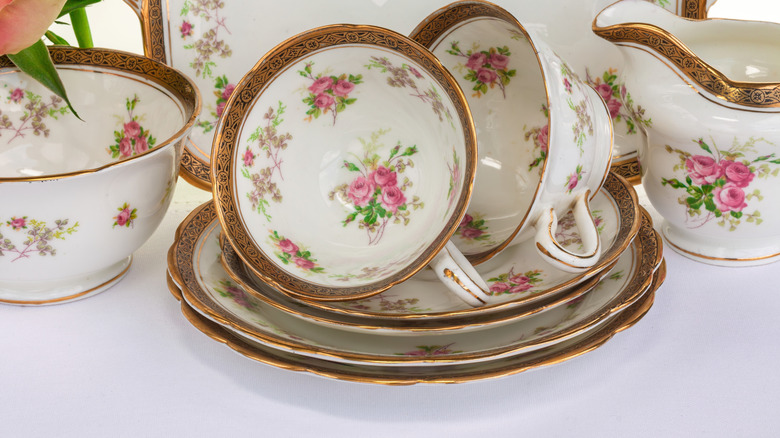 Closeup of gold rimmed antique china tea cups and plates
