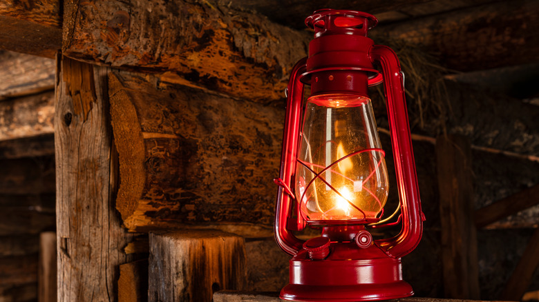 Red antique-style kerosene lantern on a ledge