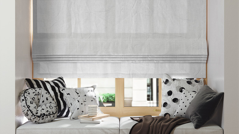 off white Roman blinds on a large window seat