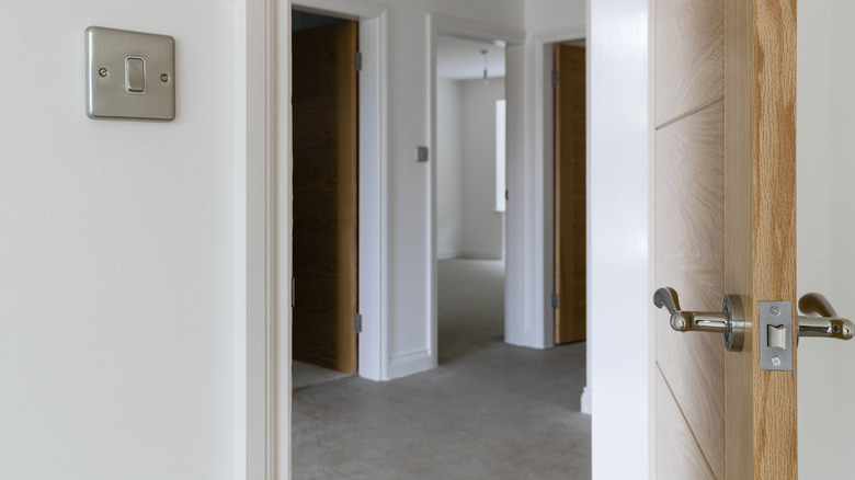 Handle and latch on a solid core door open to a hallway