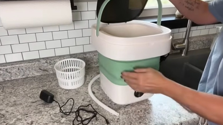 Customer using foldable washing machine on kitchen counter