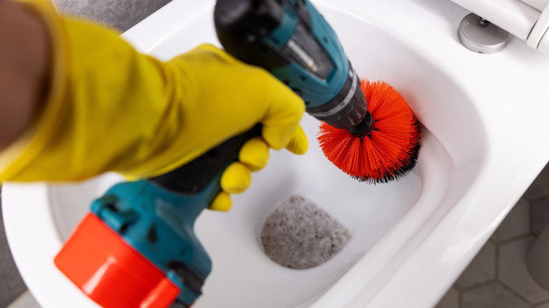 Cleaning a toilet with a spinning brush attachment on a drill