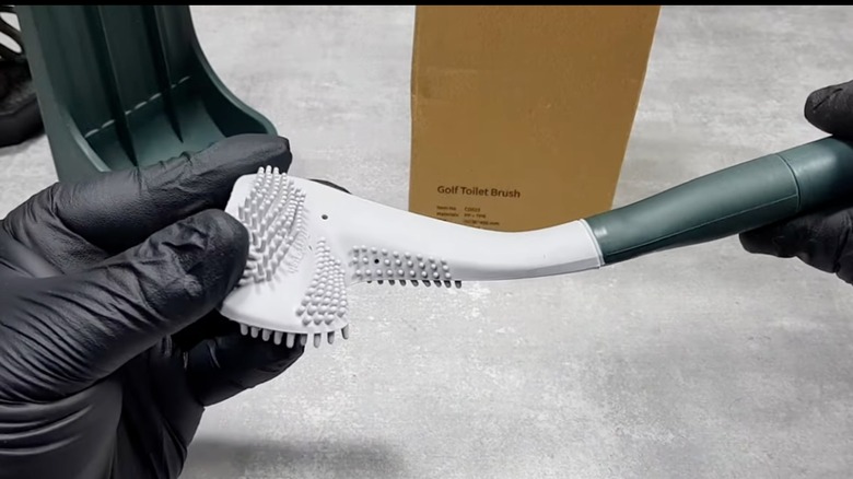 Hands holding a new silicone golf toilet brush