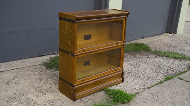 A newly restored, two-stacked barrister bookcase sittingon pavement.