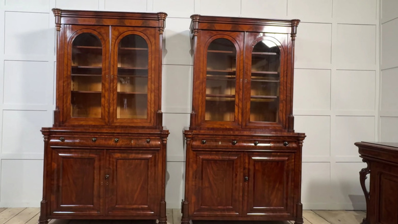 A matching pair of mahagony, Empire styled book cases sitting side by side.