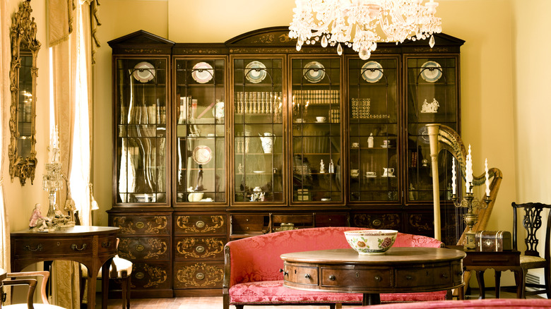 A Victorian bookcase with glass fronts and elaborate wooden inlays.