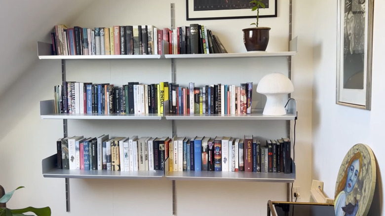 An all-aluminum Vitsoe 606 shelving unit on display in a house.