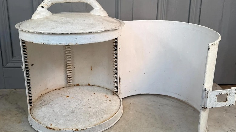 Vintage round breadbox with hinged door open.