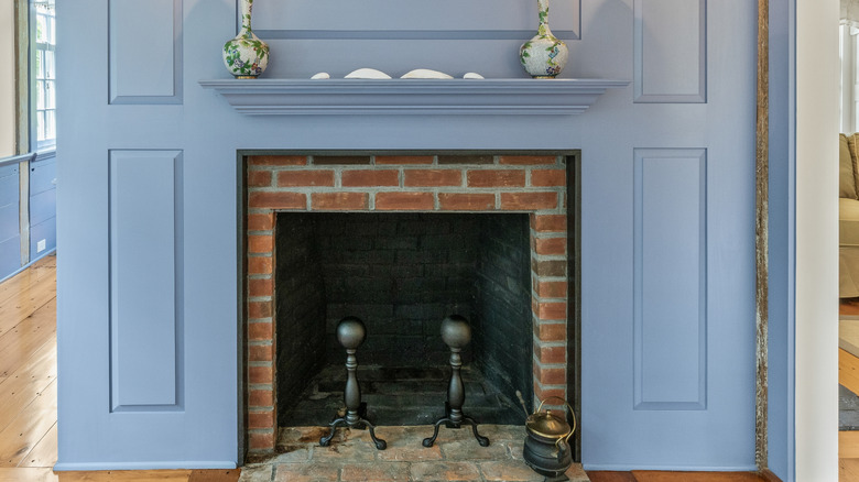 Cast iron andirons sitting in brick fireplace