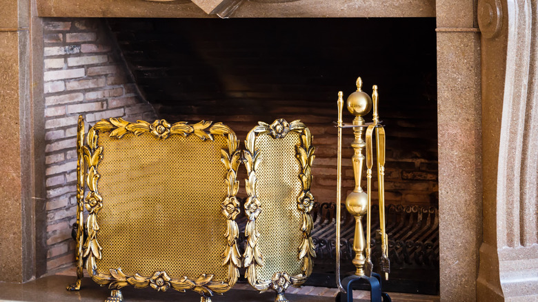 Vintage ornate gold fire screen with floral engravings