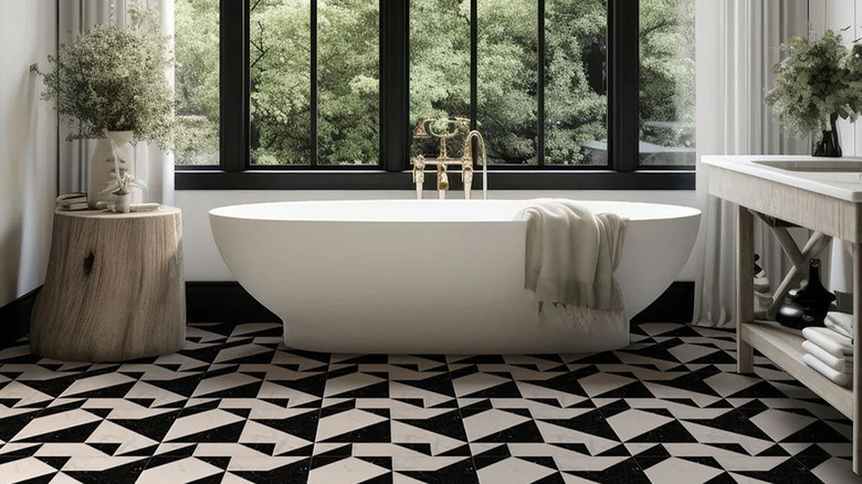 A modern bathroom feature a freestanding tub and origami-patterned tile floor