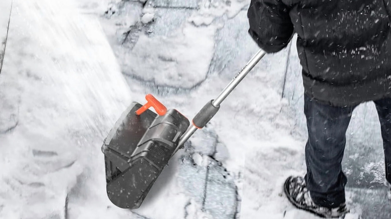 Person using electric snow shovel to clear walkway