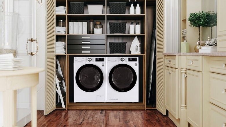 A white stacked LG front loading washer and dryer in a laundry room