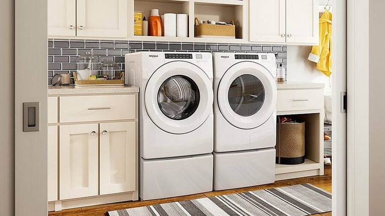 A stacked washer and dryer in a narrow laundry closet
