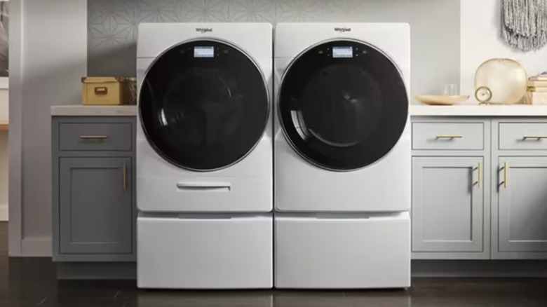 White Whirlpool front-load washer and dryer in a laundry room