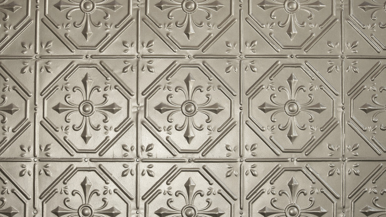 Silvery pressed tin ceiling tiles are shown in from below