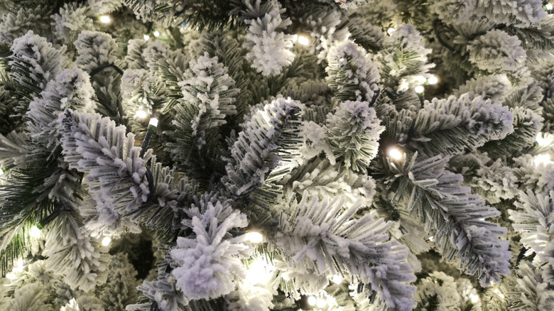 Up-close shot of a Christmas tree covered in artificial snow