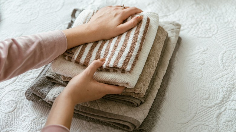 woman folding towels in neat pile