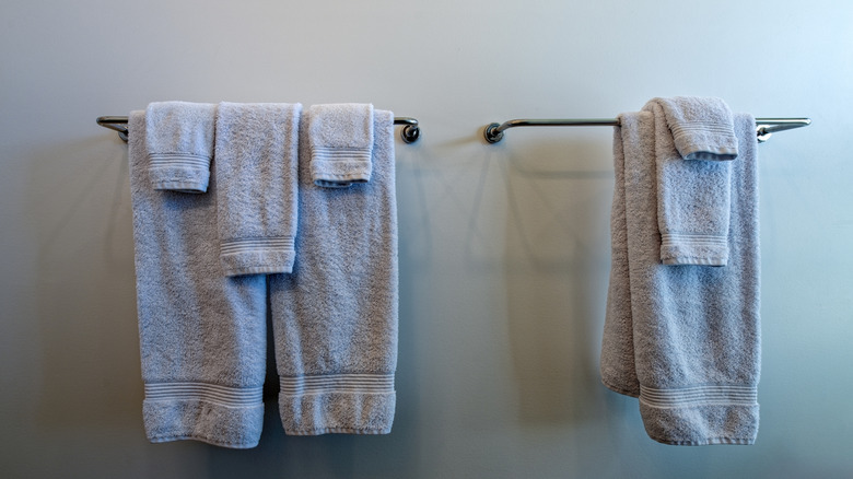 Hotel-folded towels hanging on rack.