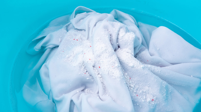 White clothing in a blue bucket with oxygen bleach and water