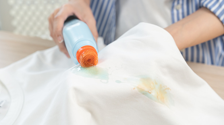 A woman cleaning a stain on white clothing