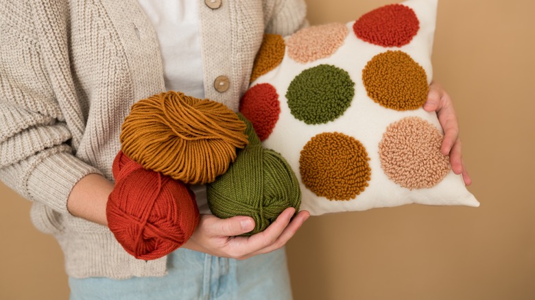 Woman holding yarn and pillow