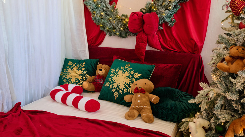 A bed decorated with Christmas pillows and surrounded by holiday decor